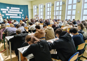 Na zdjęciu uczestnicy dyktanda piszą tekst.