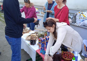 Uczestnik Pikniku rodzinnego kupuje potrawy przy stoisku z jedzeniem.
