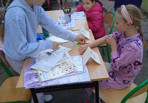 Uczestniczki podczas Pikniku rodzinnego siedzą przy stoisku z malowaniem paznokci.