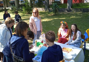 Uczestnicy Pikniku rodzinnego kupują potrawy przy stoisku z jedzeniem.