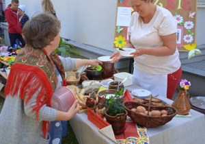 Uczestniczka Pikniku rodzinnego kupuje potrawy przy stoisku z jedzeniem.